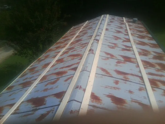 Rusted metal roof panels with new wood purlins before replacement — Storm Damage Roof Repair in Wakefield by Roofing Brothers